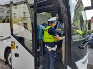 Policjant podaje kierowcy ustnik, aby przeprowadzić badanie stanu trzeźwości.