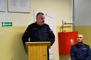 Policjant prowadzący debatę stoi przy mównicy.