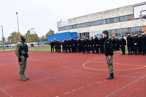 Policjant i uczniowie na boisku szkolnym.