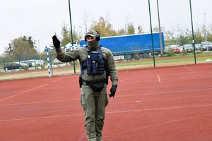 Policjant stoi na boisku szkolnym.