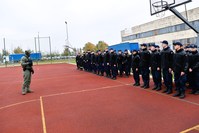 Policjant i uczniowie na boisku szkolnym.