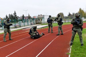 Policjanci z Grupy Realizacyjnej podczas symulacji, na boisku szkolnym.