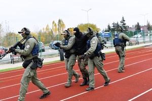 Policjanci z Grupy Realizacyjnej podczas symulacji, na boisku szkolnym.