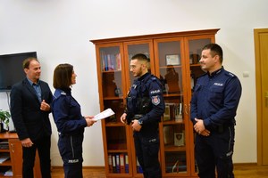 Pani Komendant i Dyrektor szkoły stoją i dziękują policjantowi, który stoi naprzeciwko nich.