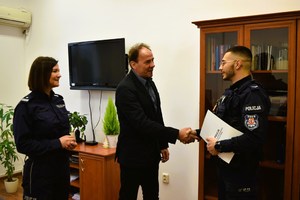 Pani Komendant i Dyrektor szkoły stoją i dziękują policjantowi, który stoi naprzeciwko nich.