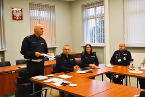 Uczestnicy spotkania siedzą przy stole w sali konferencyjnej Komendy Powiatowej Policji w Śremie.