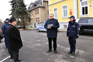 Policjanci i zaproszeni goście stoją przed budynkiem Komendy.